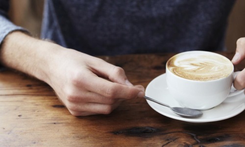 a person holding a cup of coffee