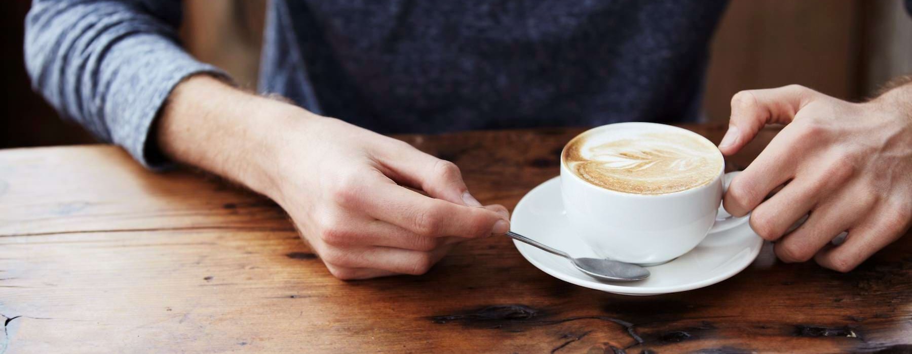 a person with a coffee cup and spoon