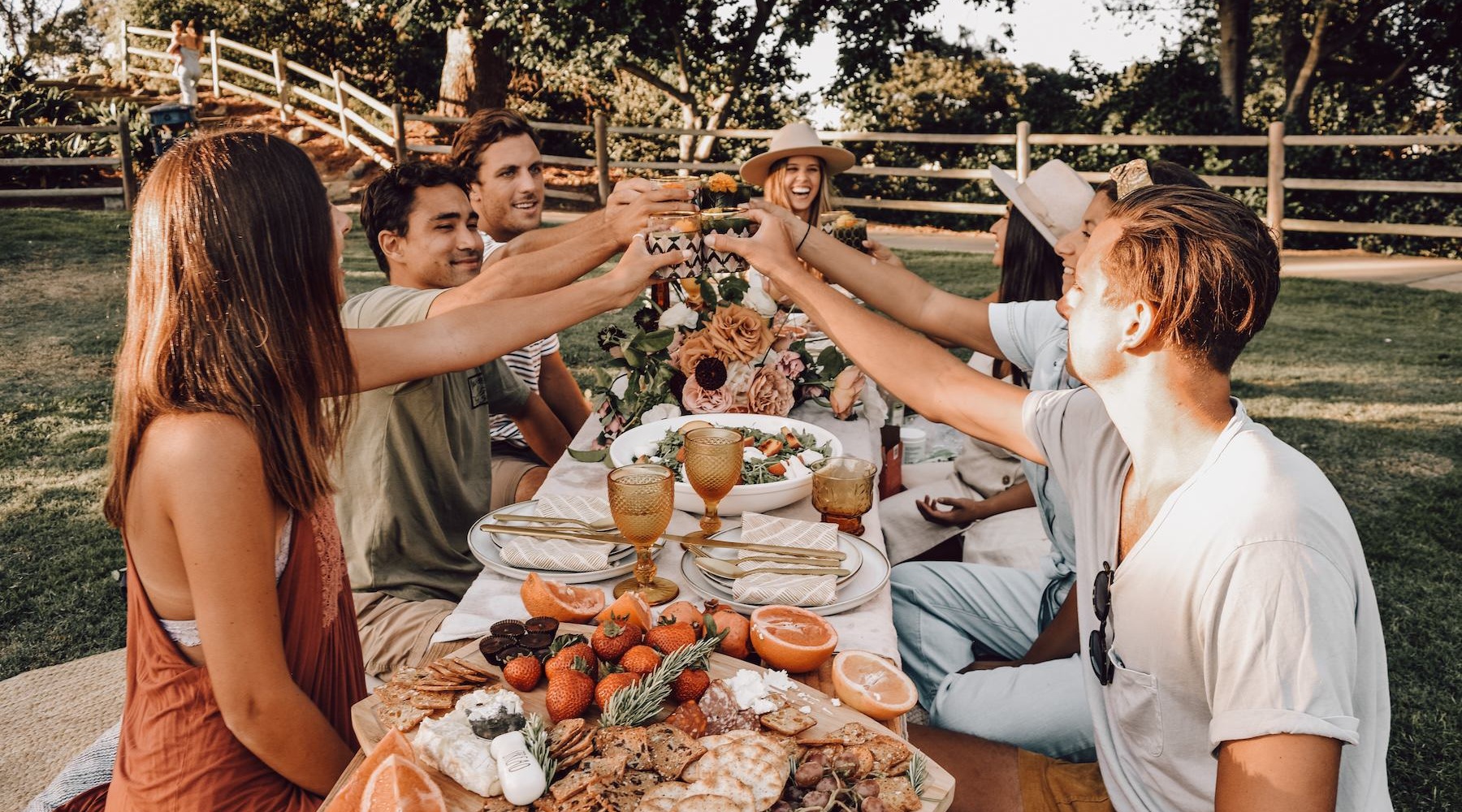 a group of people together at a dinner table outside