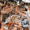 a group of people together at a dinner table outside