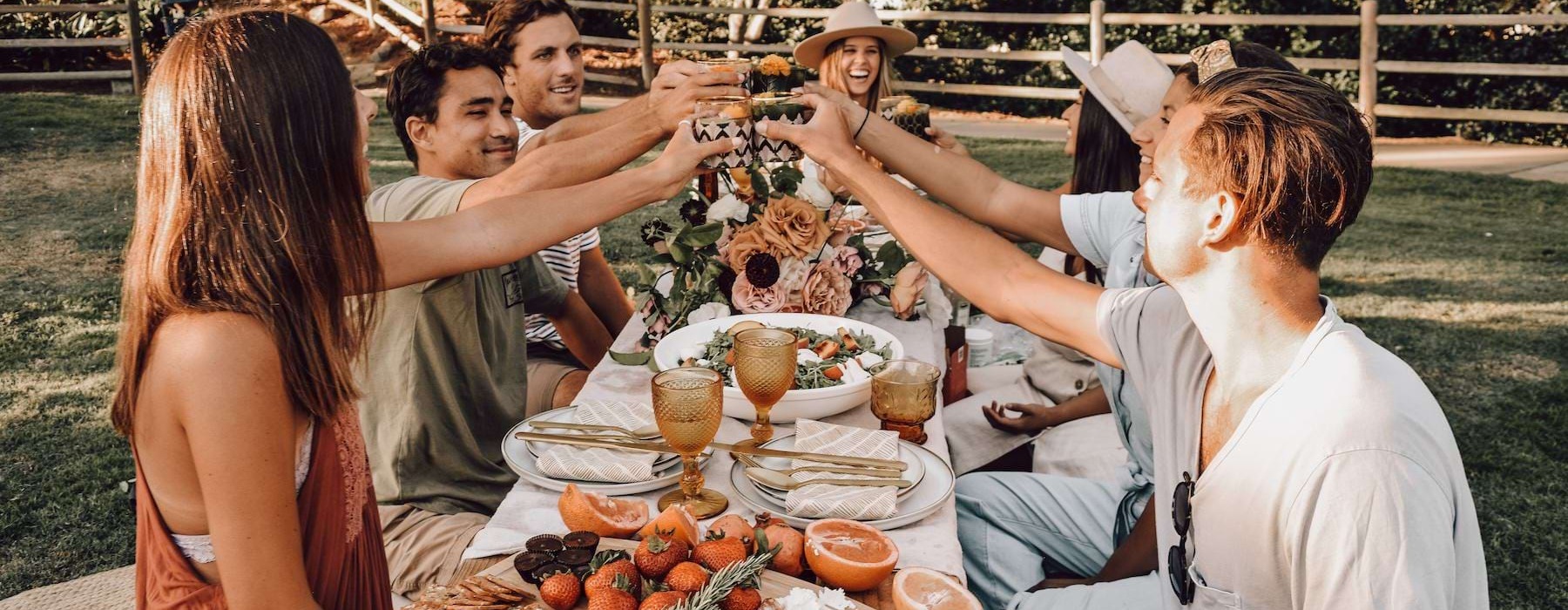 a group of people together at a dinner table outside